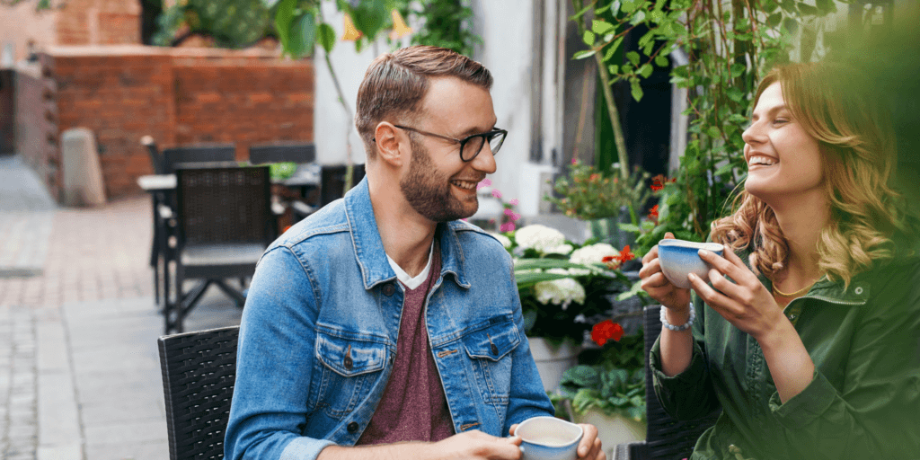 What do matchmaker do and how much do they cost? A happy couple enjoy espresso drinks in the patio of a coffee shop.