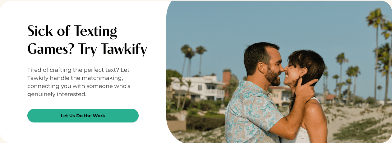 A male and female couple embrace on the beach with palm trees in the background.