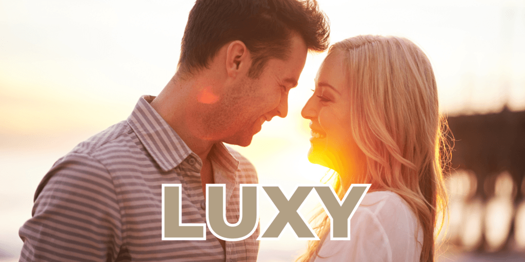 Luxy matchmaking service photograph of man and woman enjoying a sunset at the beach together.