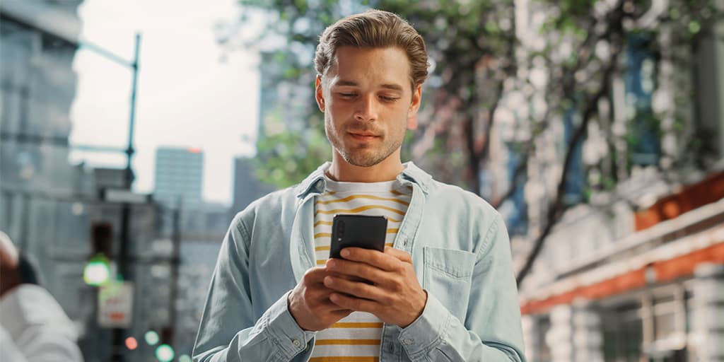 A man types matchmaking questions on his phone in preparation for his first matchmaking consultation.