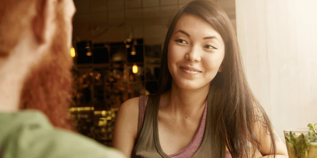 How to deal with a partner who has commitment issues. A woman smiles at her boyfriend as they have a conversation about commitment in their relationship.