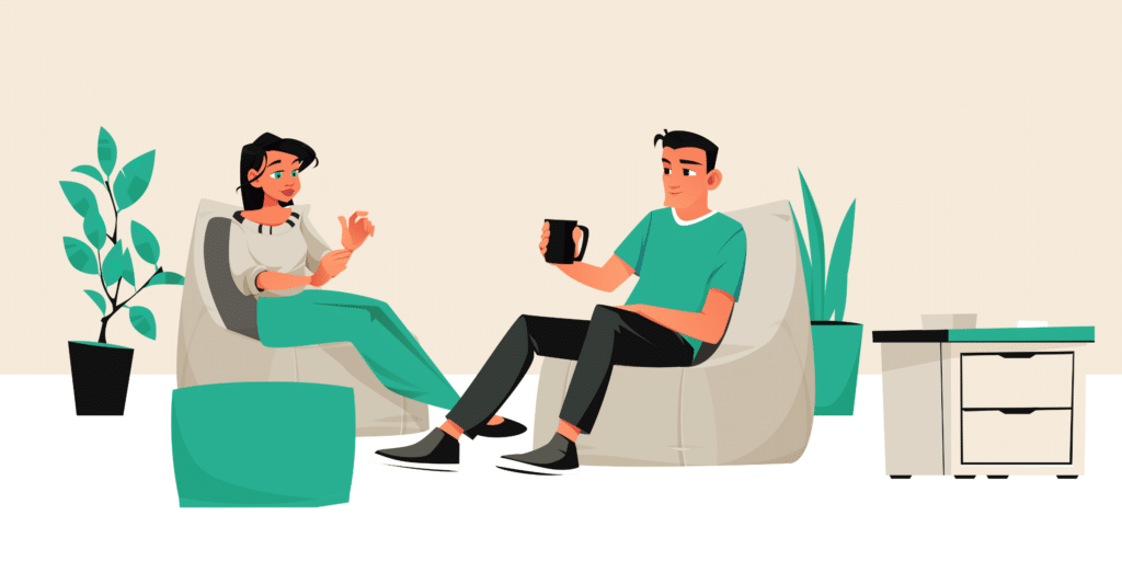Man and woman sitting down drinking a hot beverage and chatting.