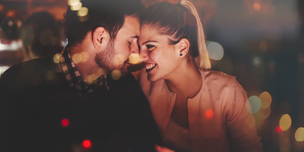 A happy couple shares an intimate moment while out on a date.